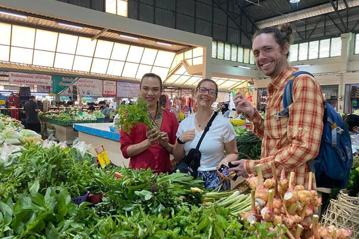 un grup de persones dempeus en un mercat amb verdures