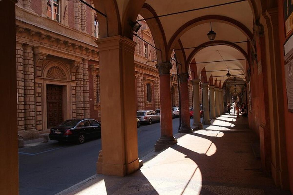 un vicolo con archi e auto parcheggiate su una strada