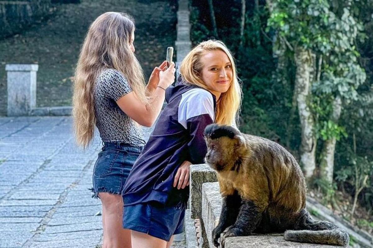 seorang wanita mengambil gambar seorang gadis dan seekor monyet