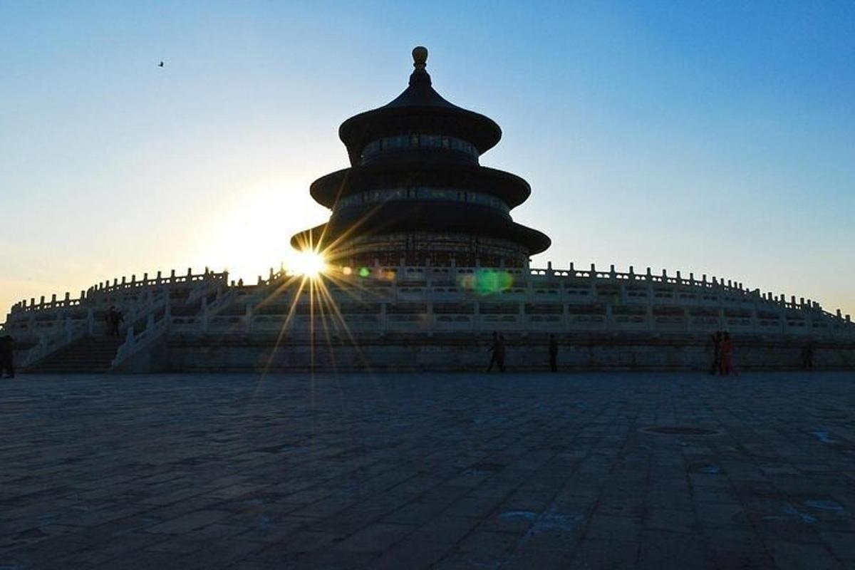 un grande edificio con il sole che tramonta dietro di esso