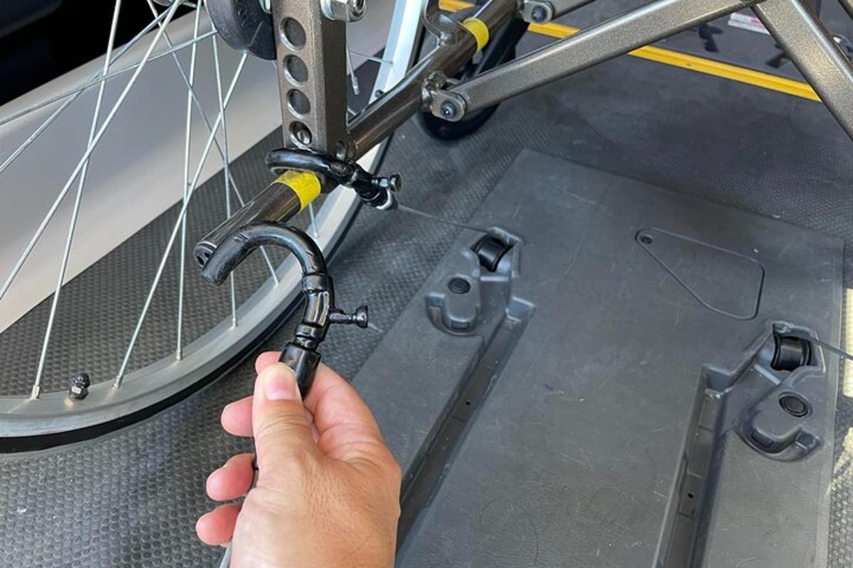 una persona que sostiene una rueda de bicicleta con una llave inglesa