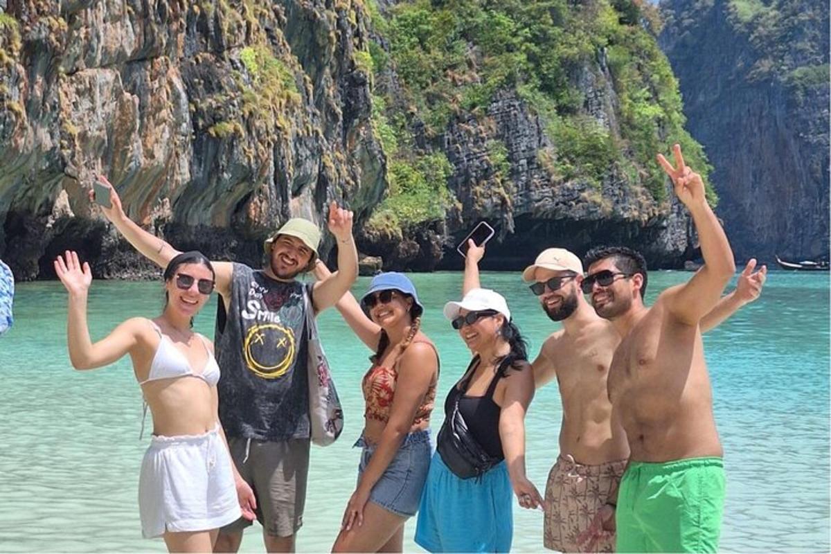 Un grupo de personas de pie en el agua en la playa.