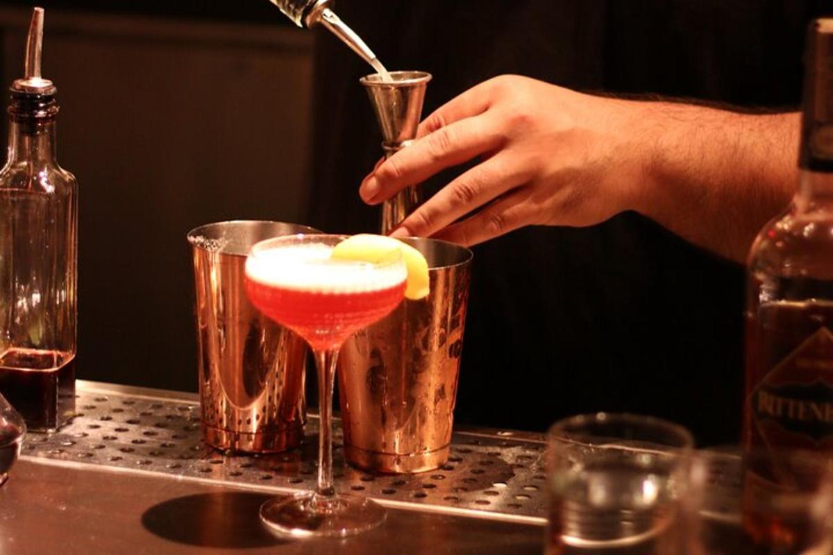 seseorang menuang minuman ke dalam gelas martini