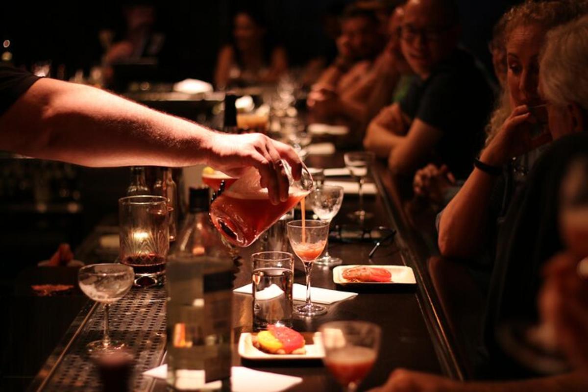 uma pessoa servindo uma taça de vinho em um bar