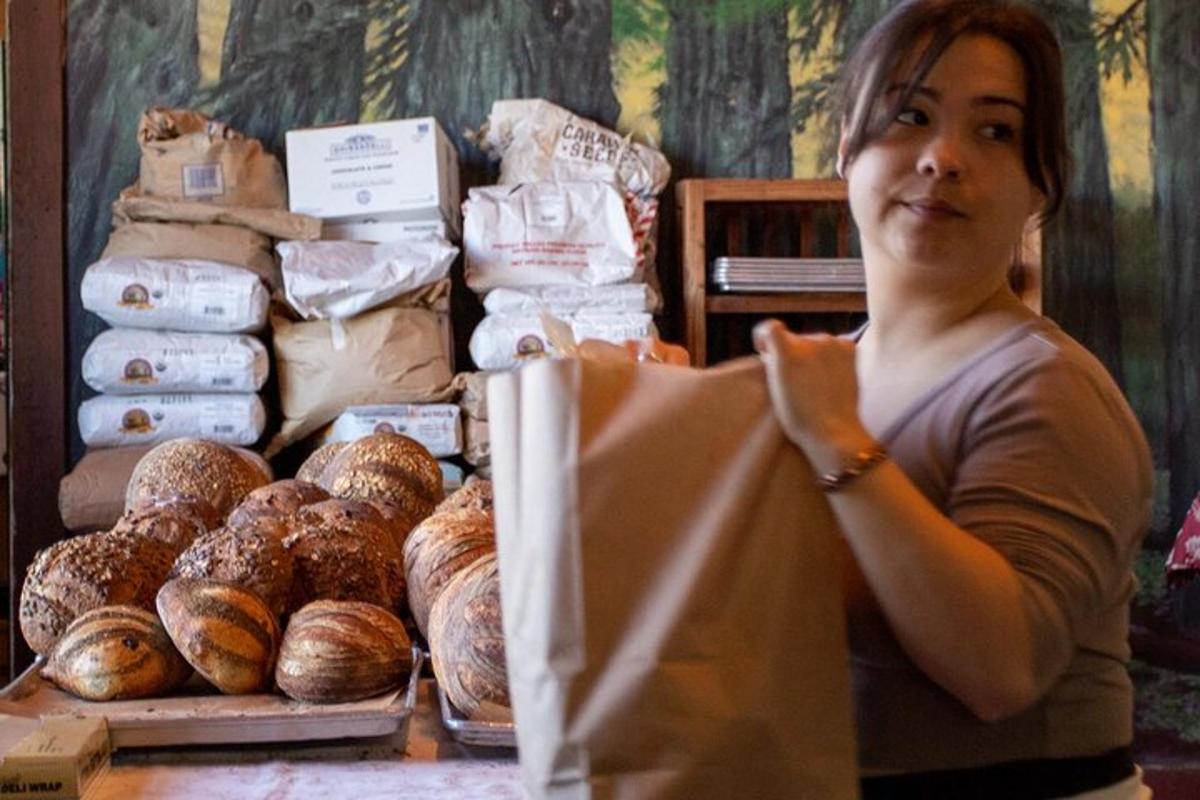 una donna in piedi davanti a un tavolo con il pane