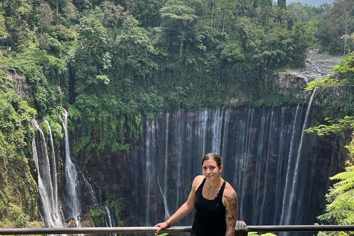a woman standing in front of a waterfall
