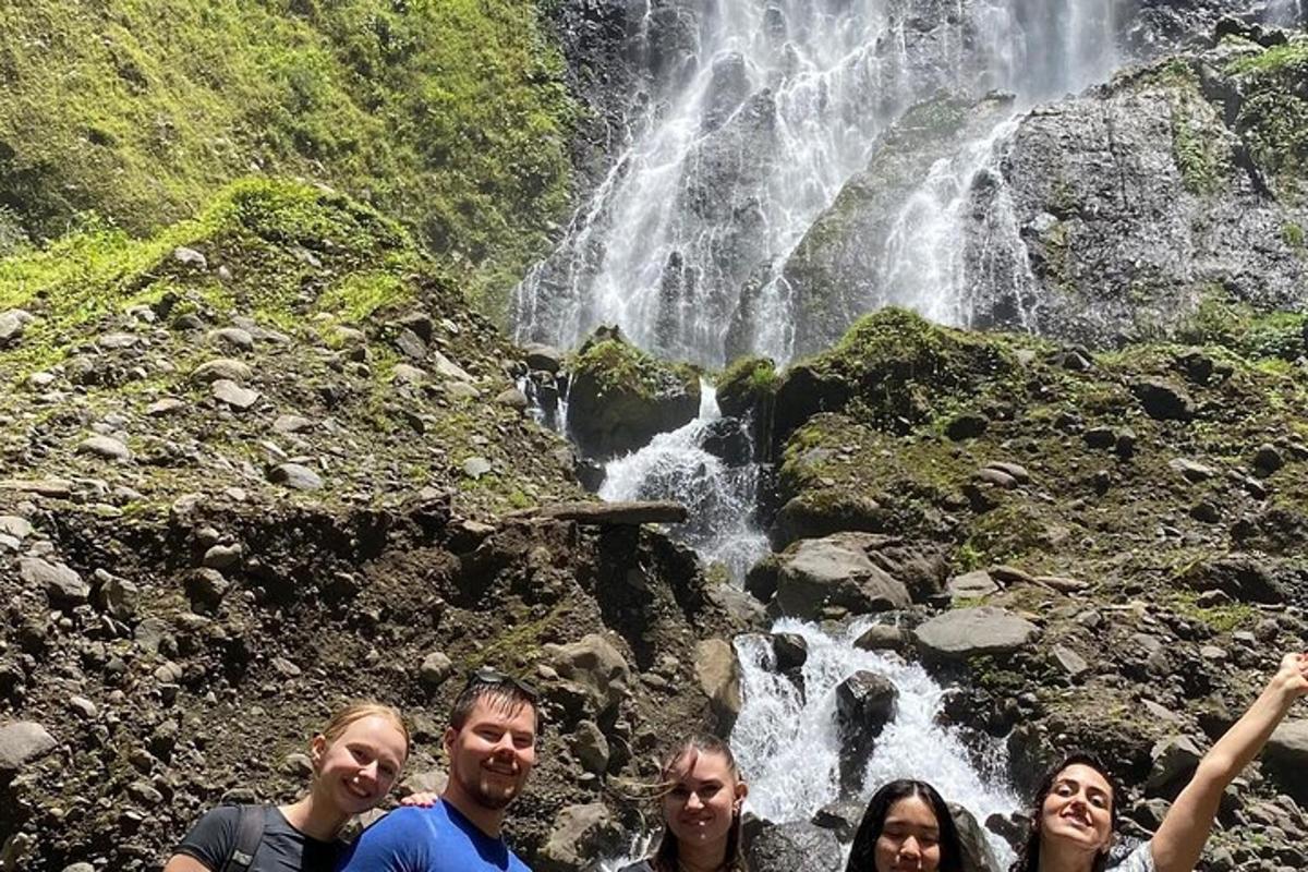 a group of people standing in front of a waterfall