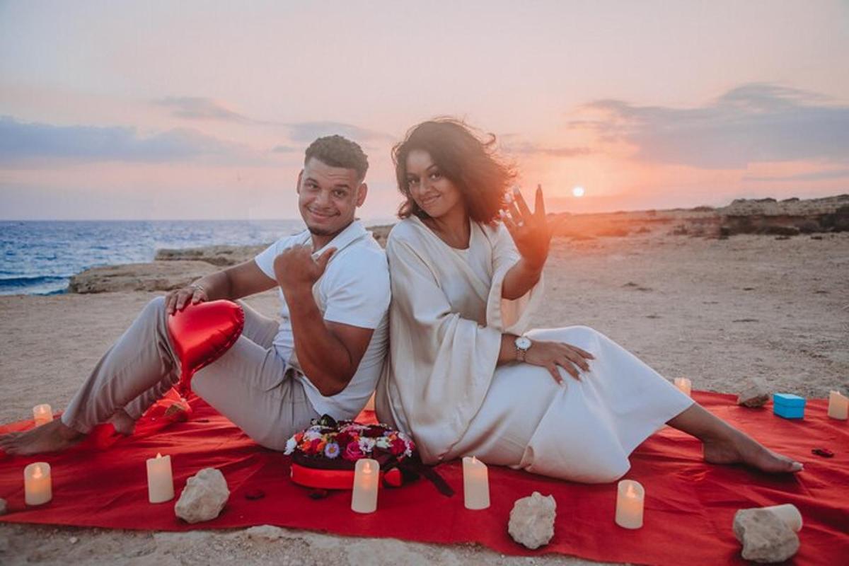 um homem e uma mulher sentados em um cobertor na praia