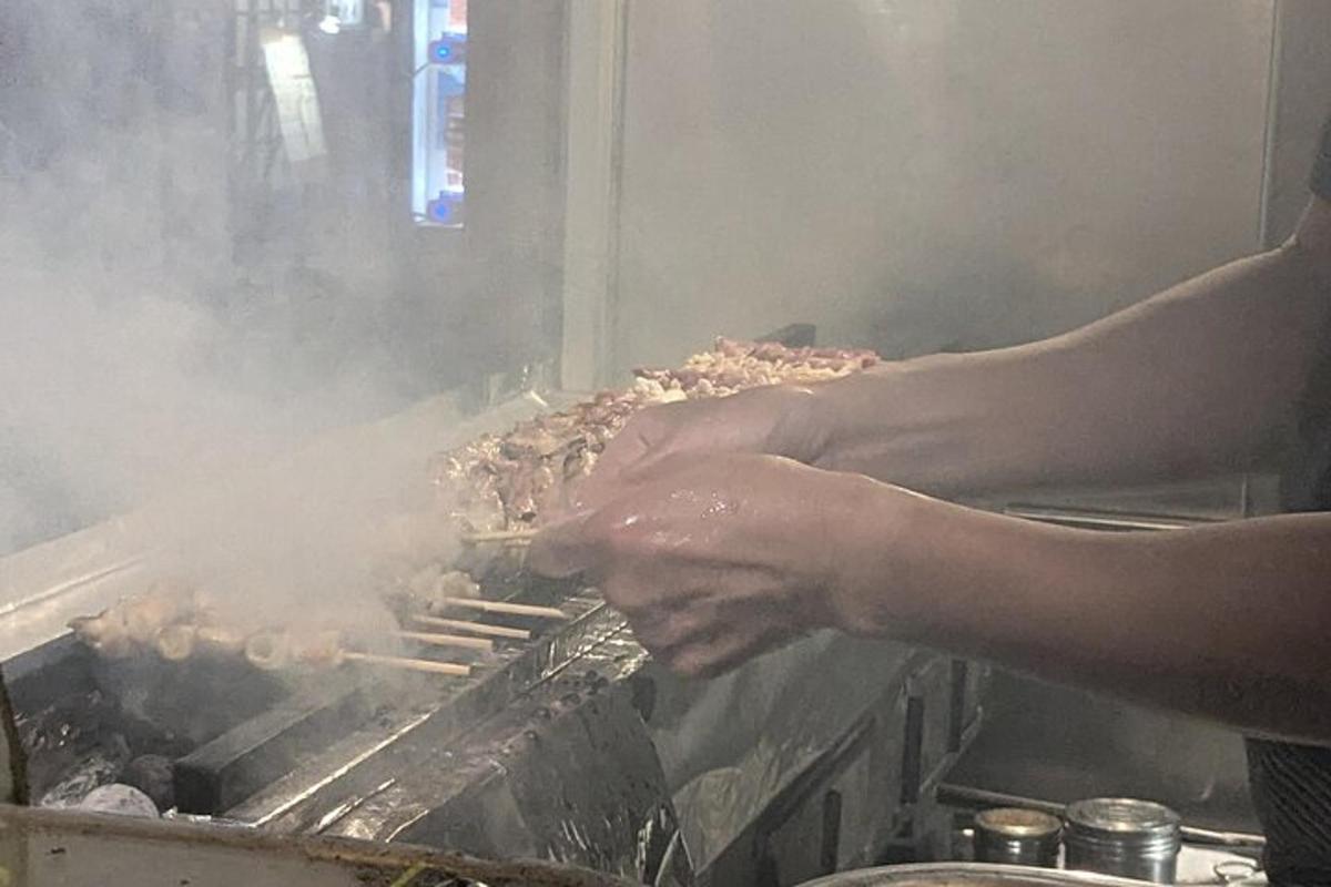 maður er að elda mat á grilli