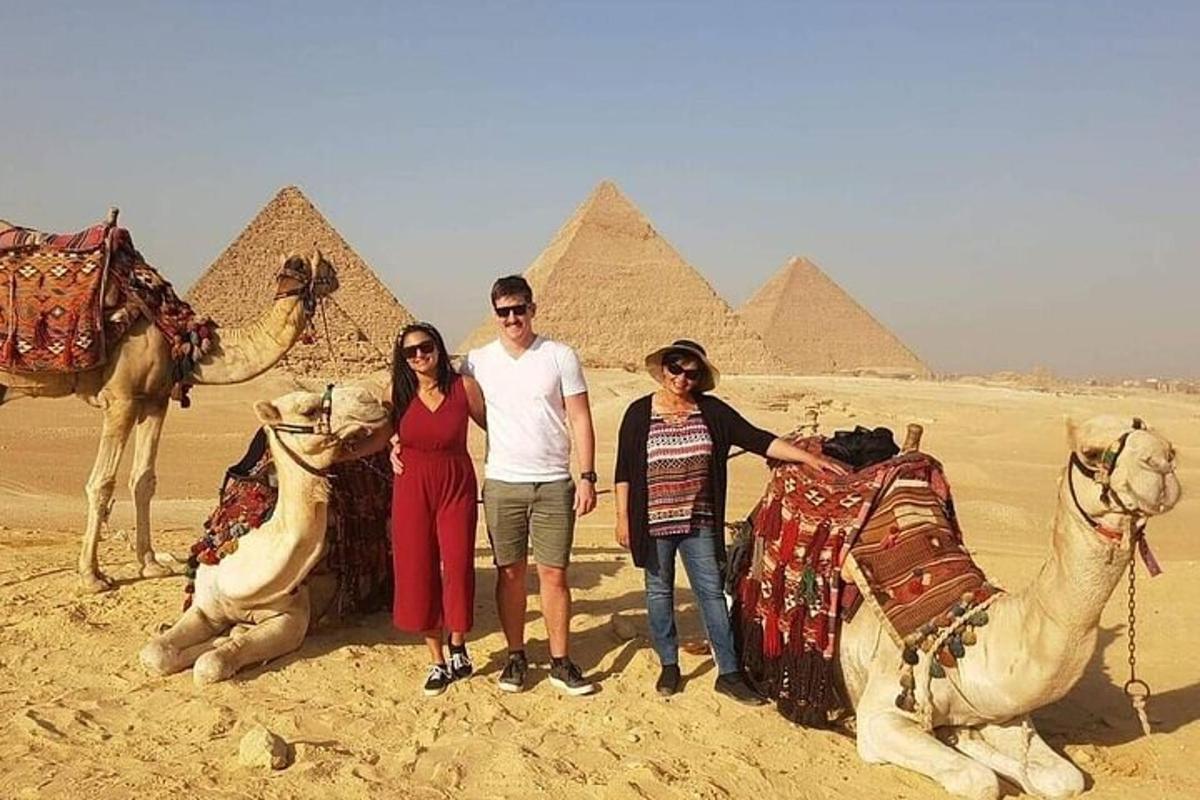 un gruppo di persone in piedi davanti alle piramidi