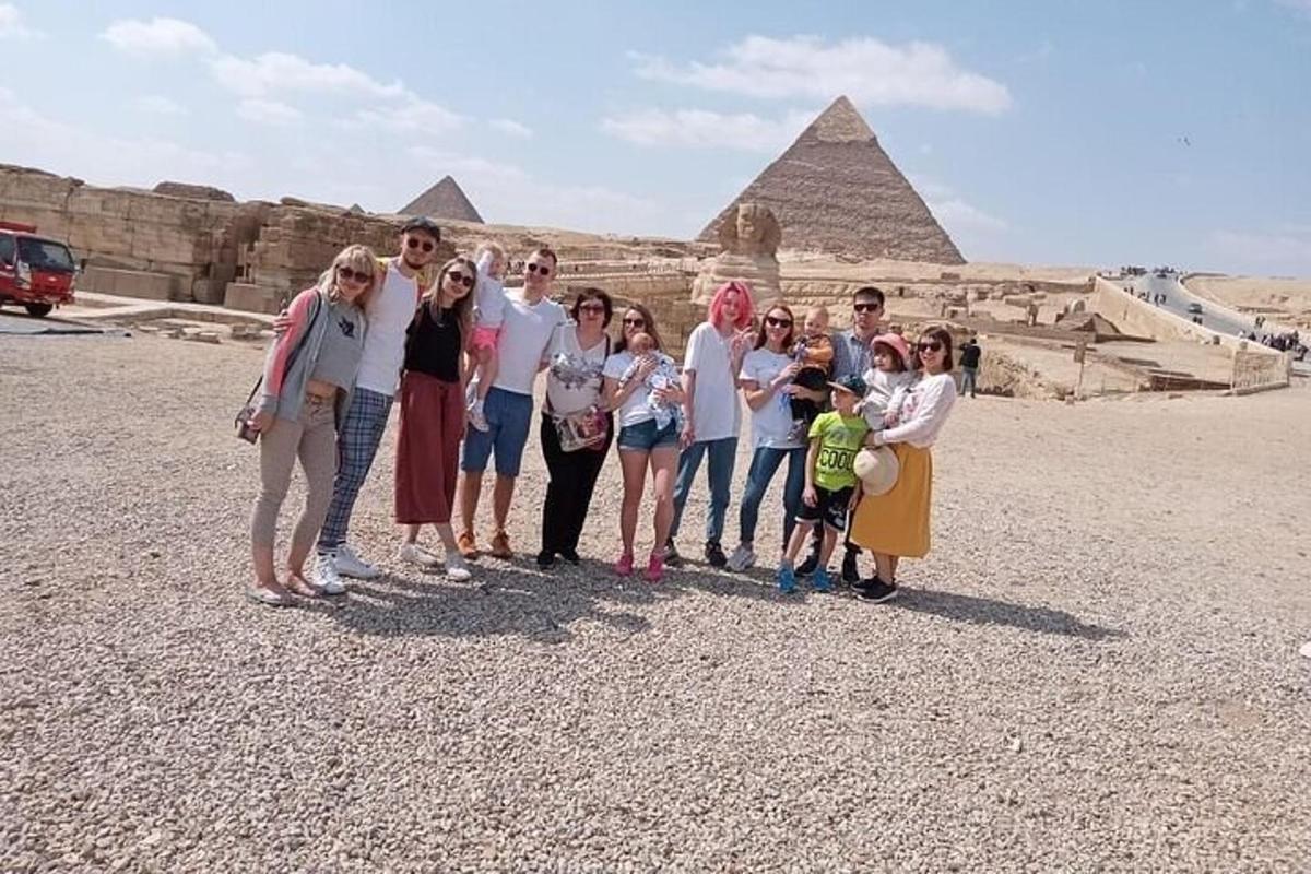 un gruppo di persone in piedi davanti alle piramidi