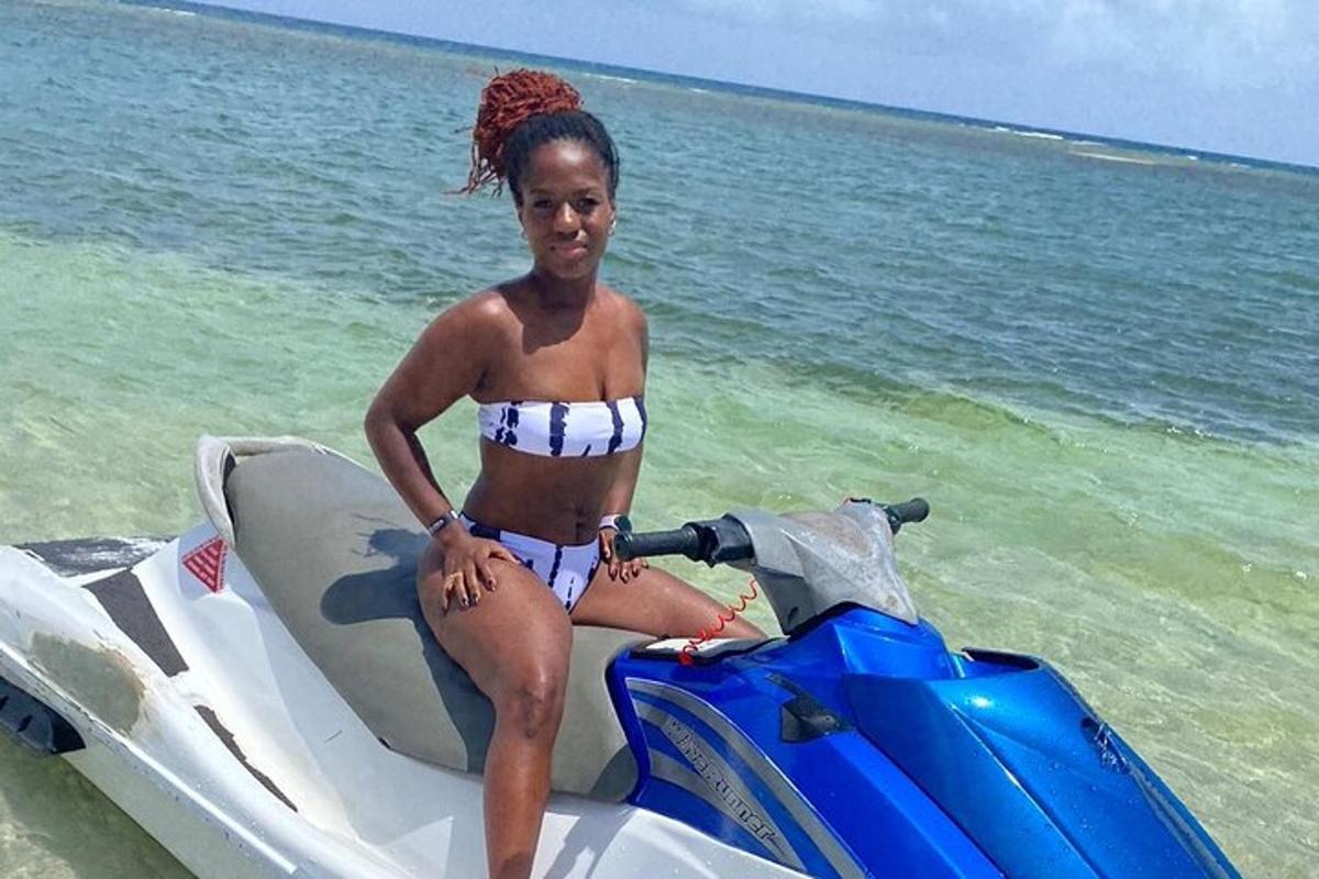 seorang wanita berbikini duduk di atas jet ski di pantai
