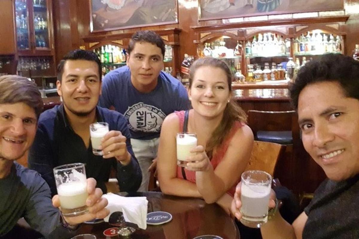 Un grupo de personas sentadas en una mesa con bebidas.
