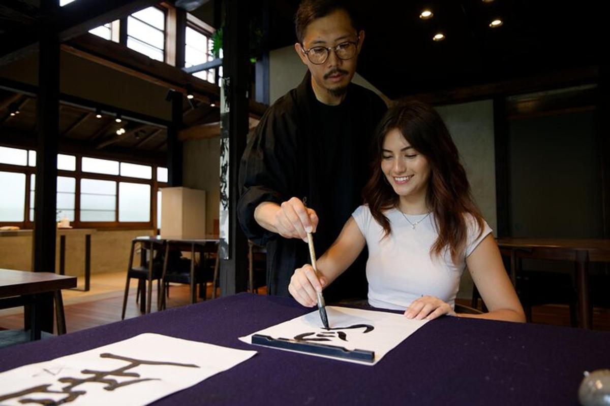 a woman sitting at a table cutting a piece of paper