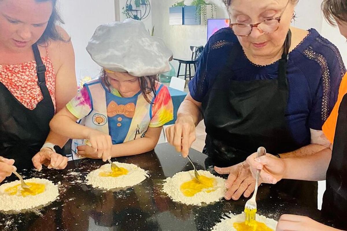 a group of women and a little girl making cupcakes