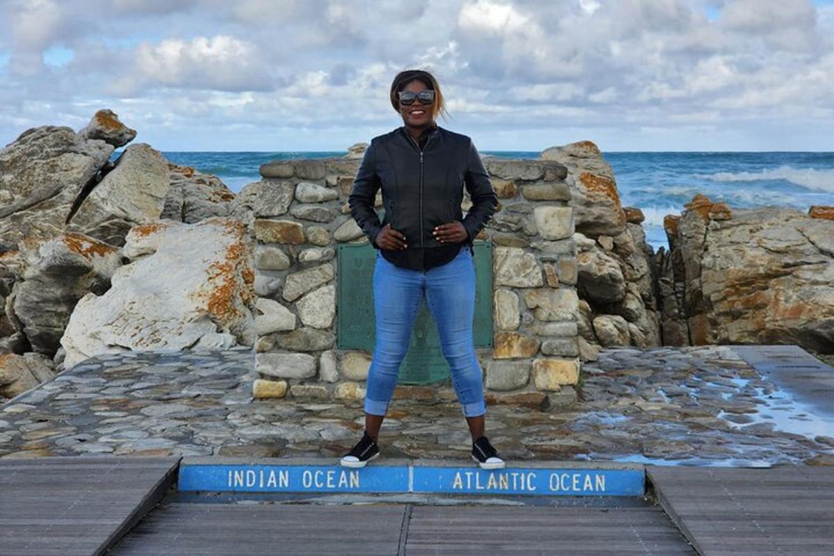 una donna in piedi su un cartello in riva all'oceano