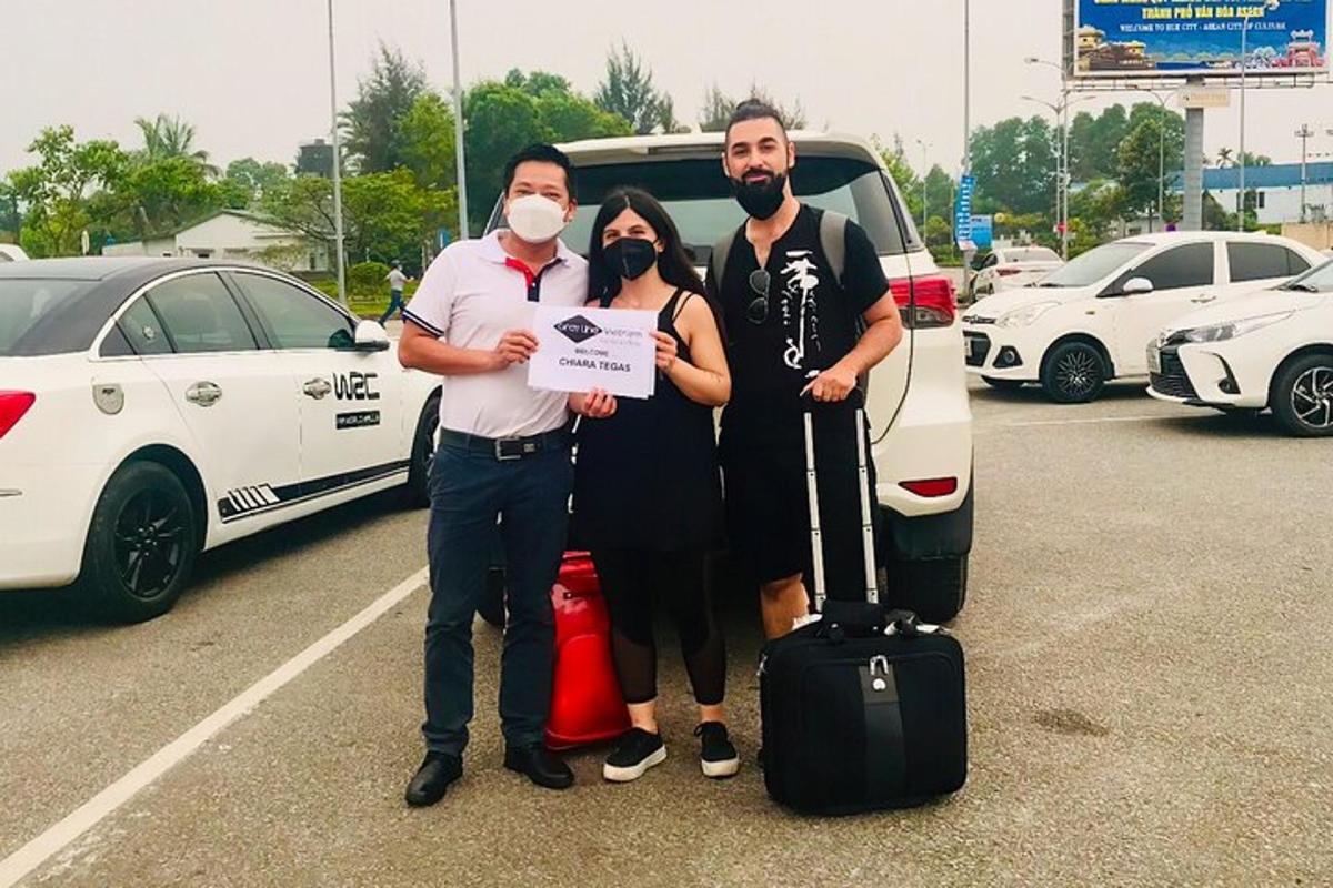 Un grupo de tres personas de pie en un estacionamiento.