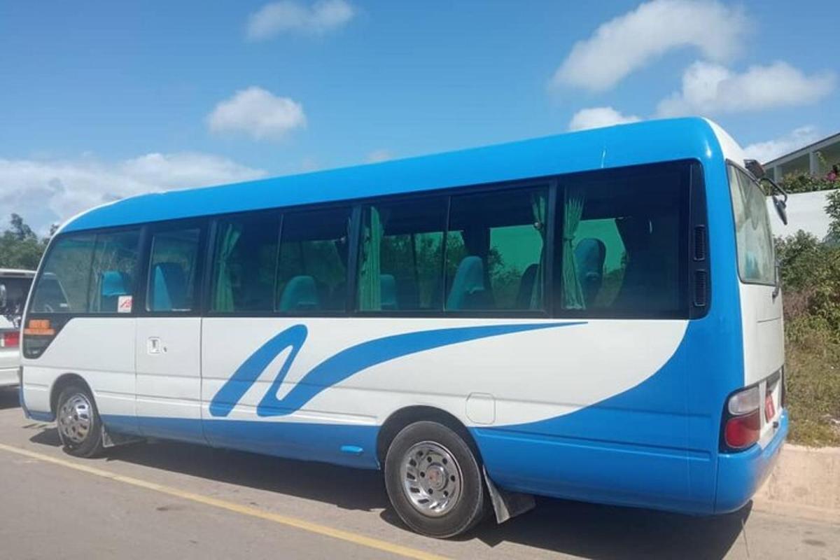 một chiếc xe buýt màu xanh và trắng đỗ trong bãi đậu xe