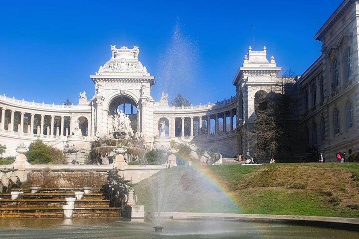 a rainbow in front of a building with a fountain