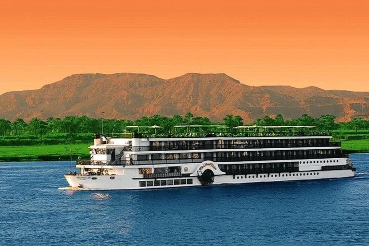 sebuah kapal persiaran di atas air dengan latar belakang gunung