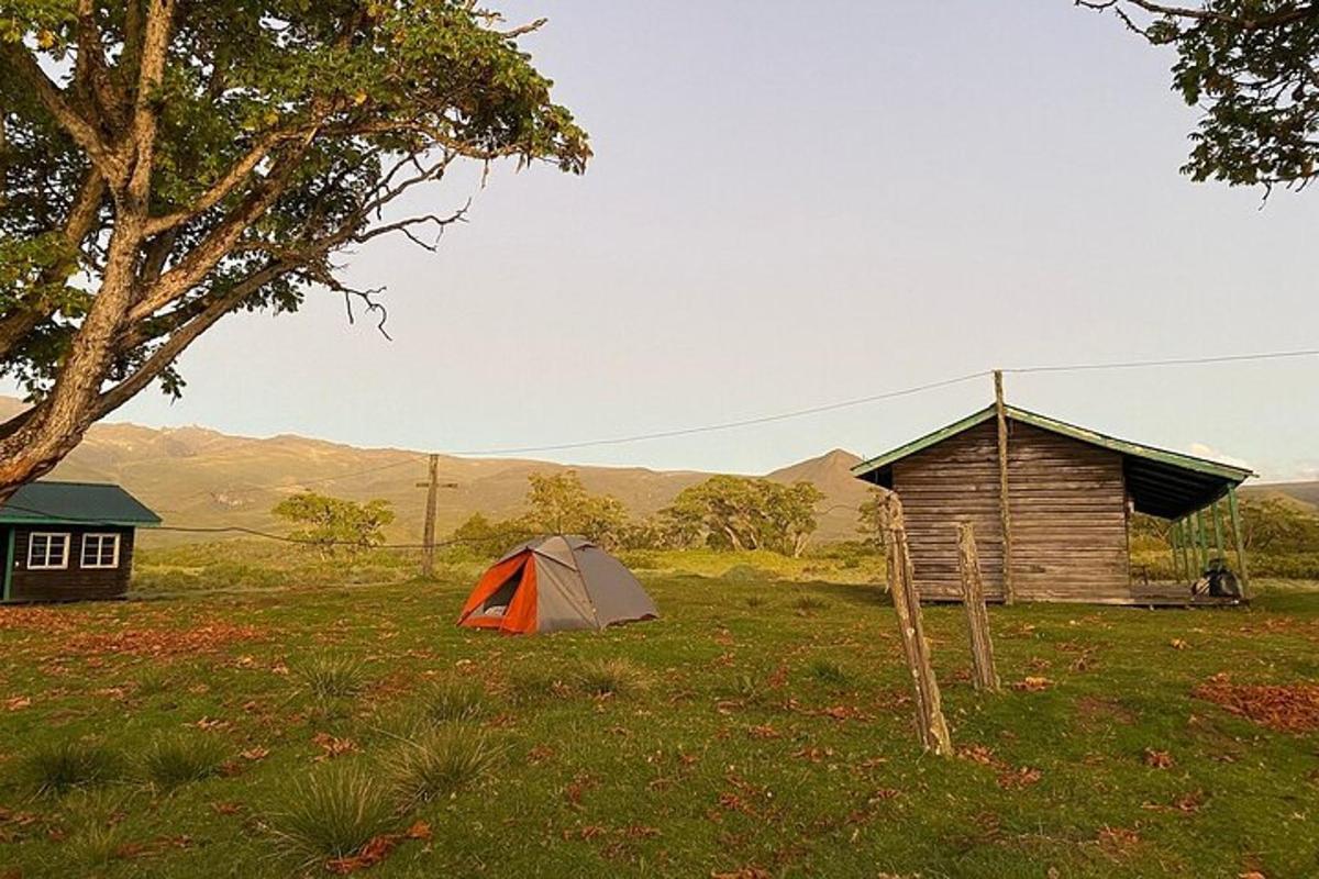 una tenda in un campo accanto a una cabina