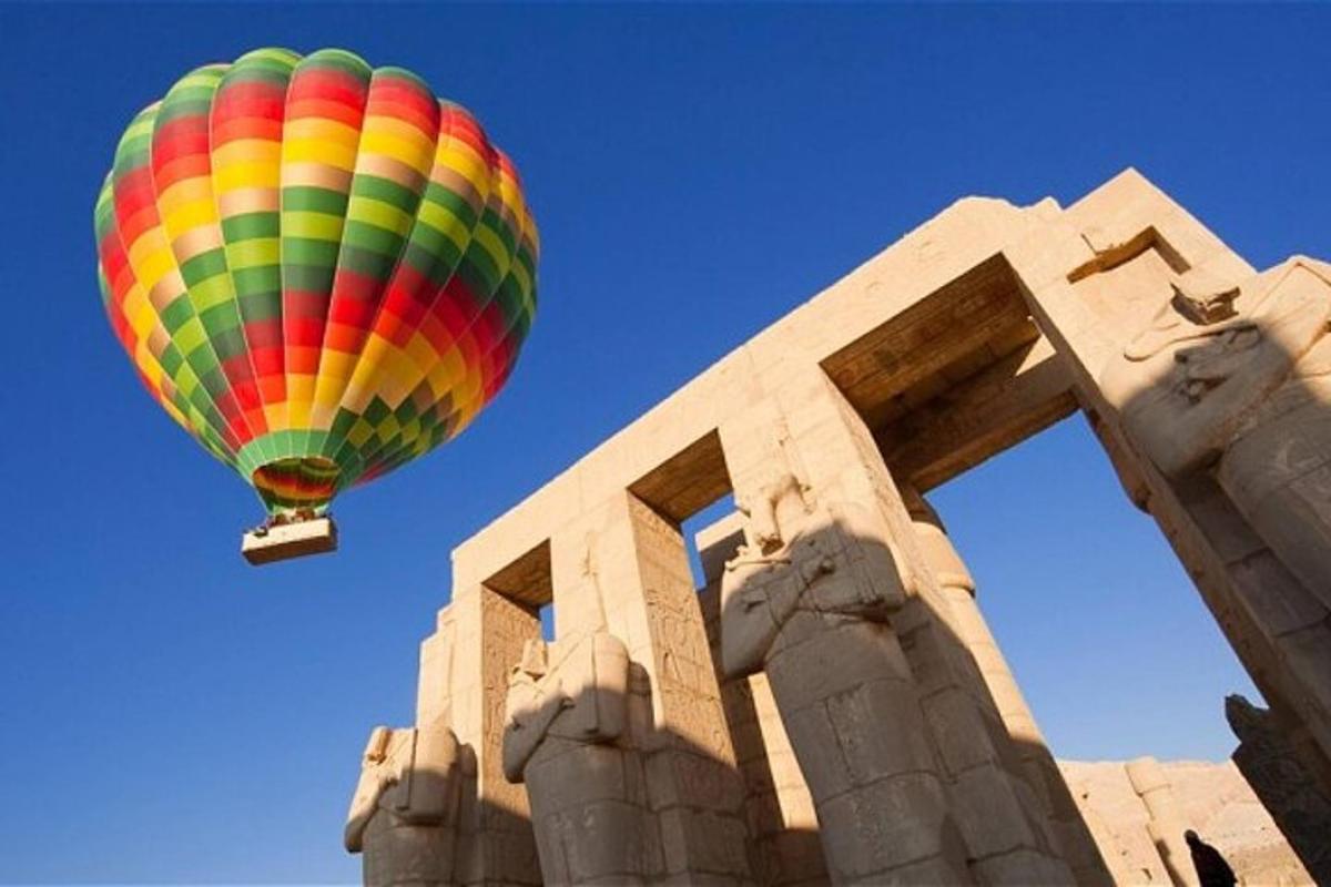 šareni balon na vrući zrak leti iznad zgrade