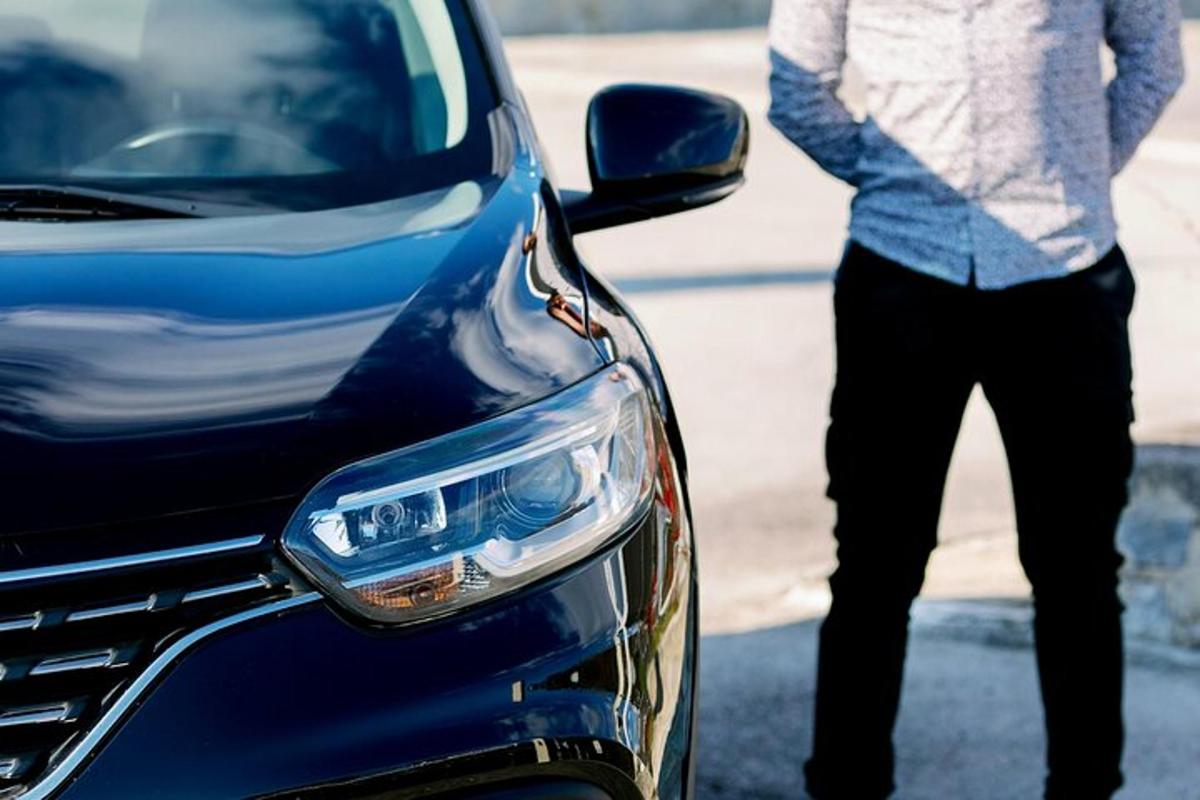 un uomo è in piedi accanto a un'auto