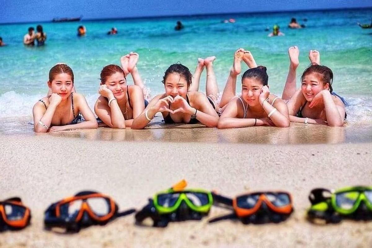 Un grupo de niños tumbados en la playa con sus gafas.