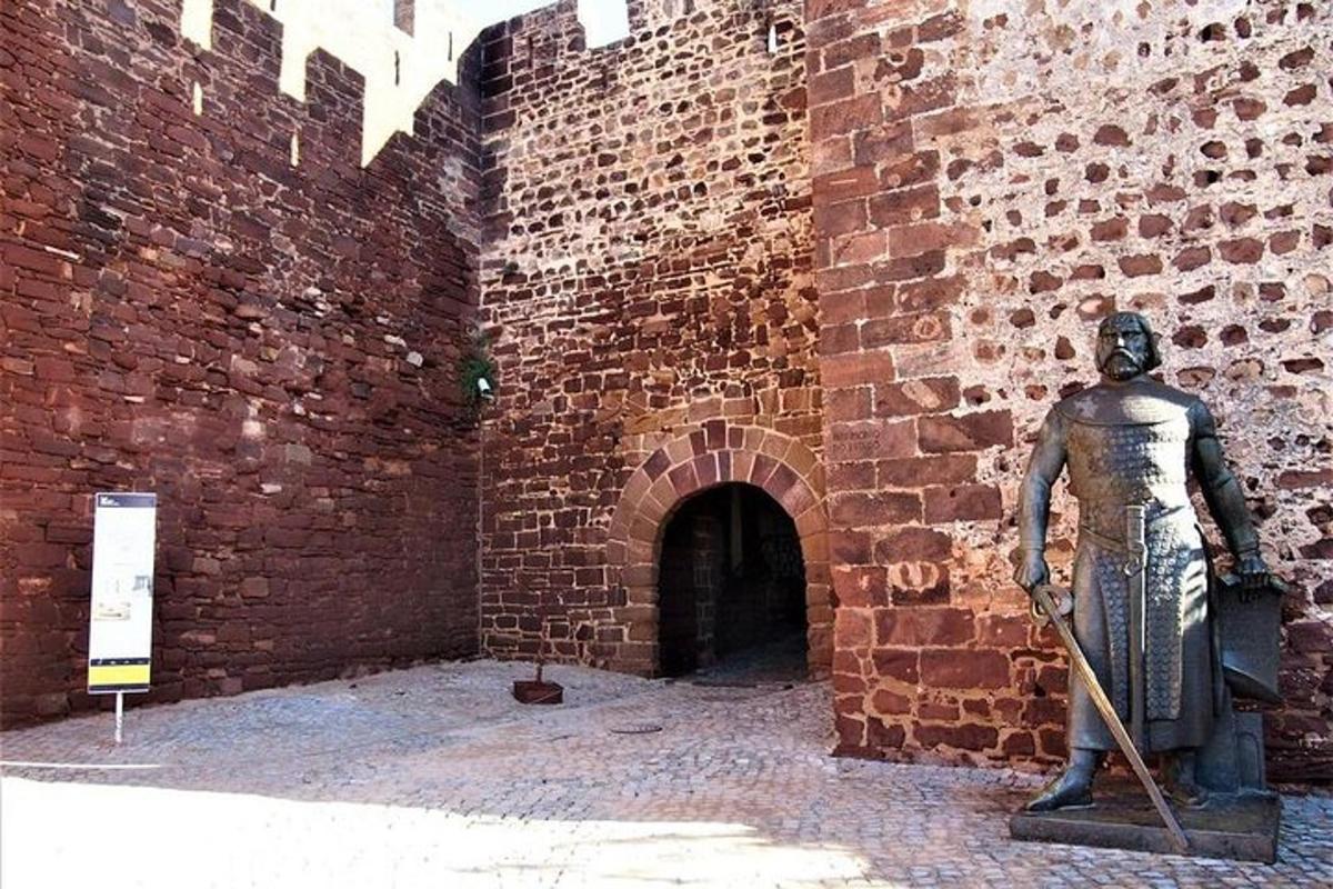 a statue of a man standing next to a brick wall