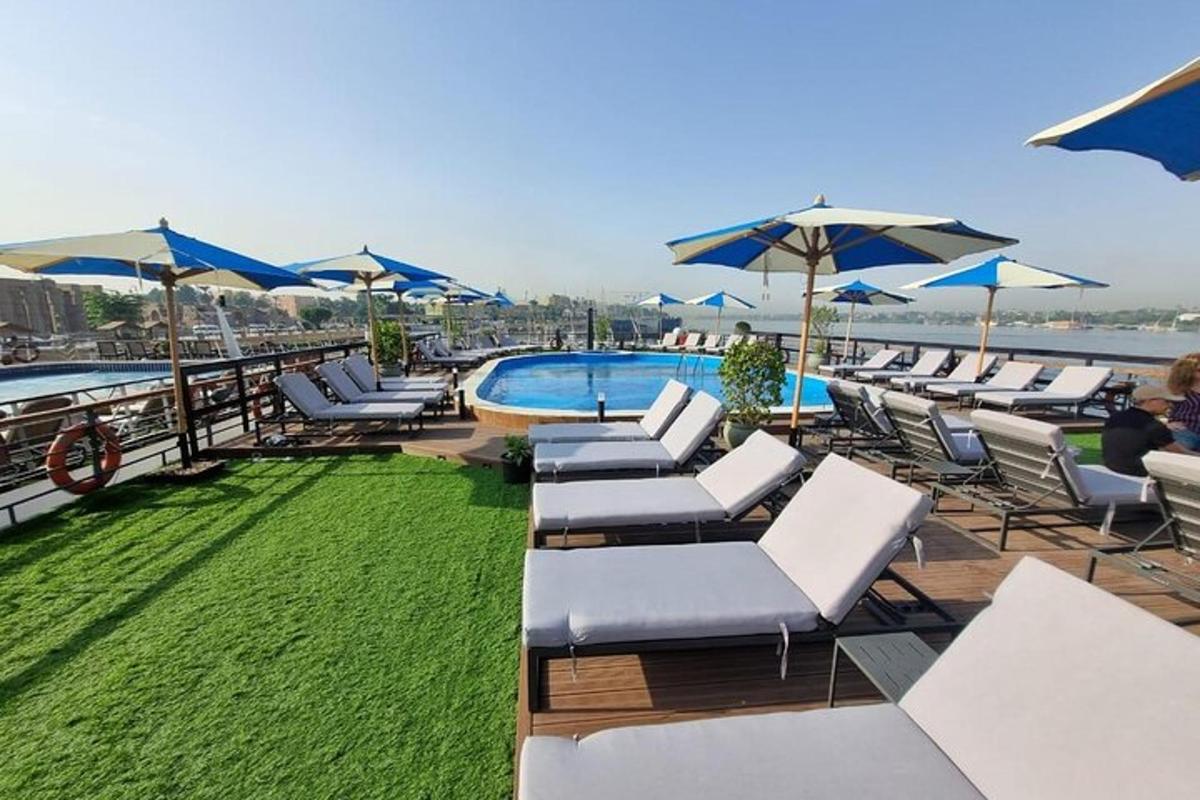 un grup de șezlonguri și umbrele lângă o piscină