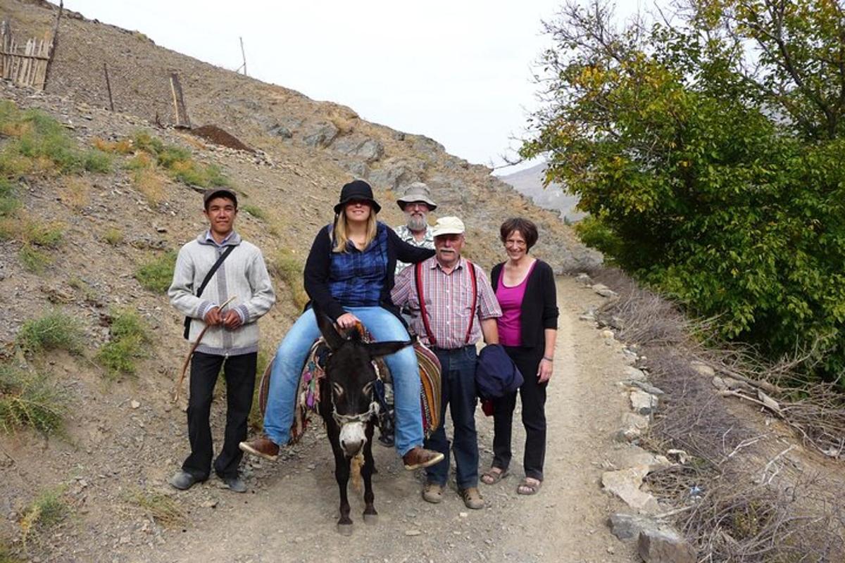 a group of people riding a horse on a dirt road