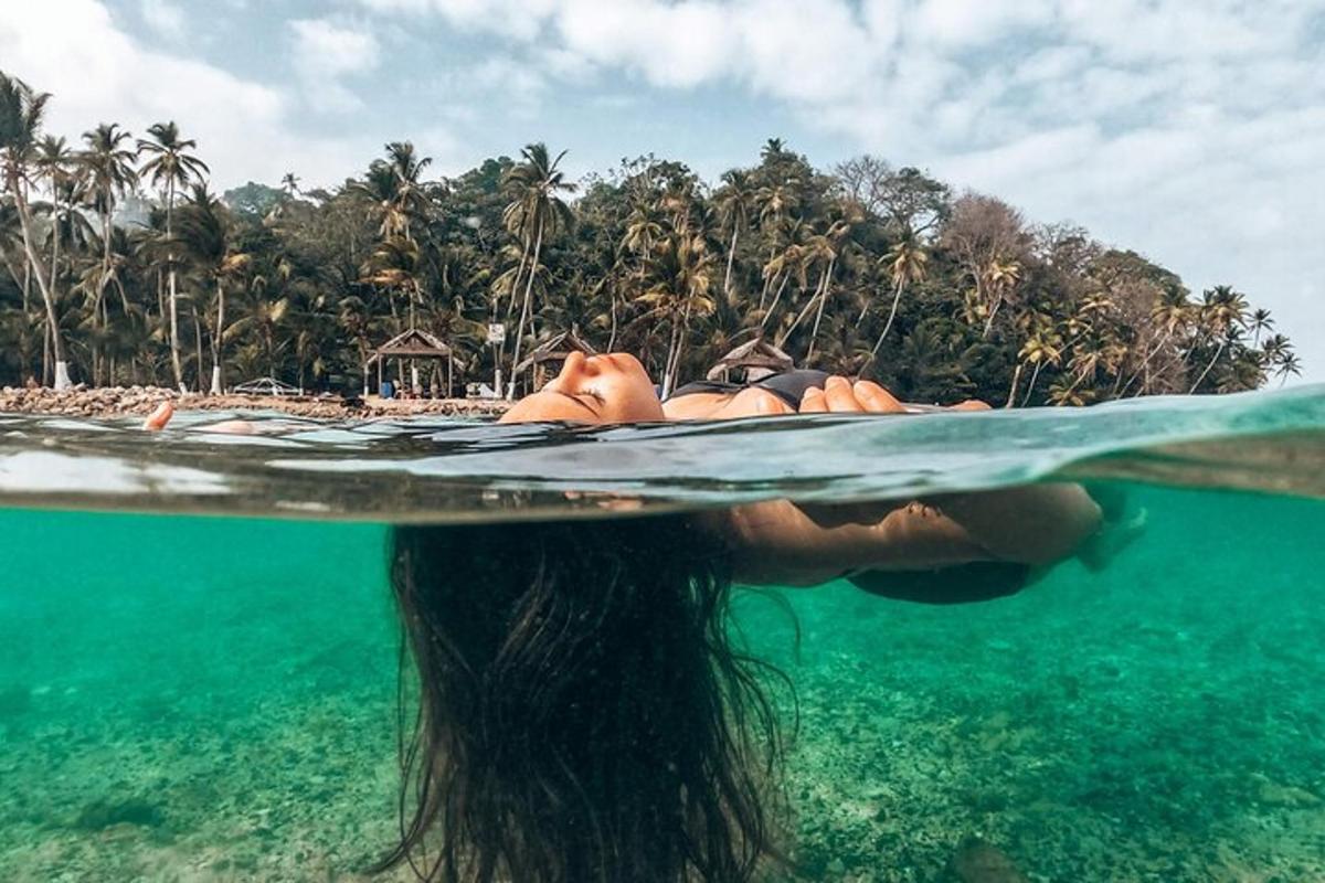 žena ležící na surfovém prkně v oceánu