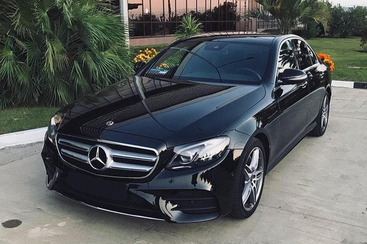a black mercedes benz car parked in a driveway