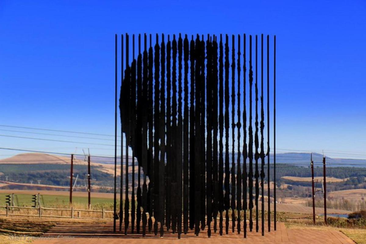 a large black metal sculpture on the side of a road