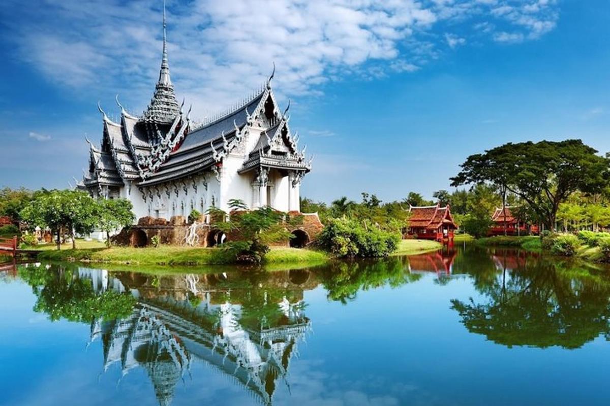 a large white building with its reflection in the water