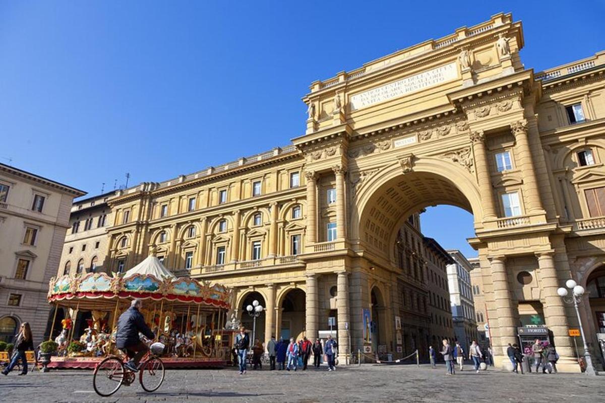 un home anant en bicicleta davant d'un edifici