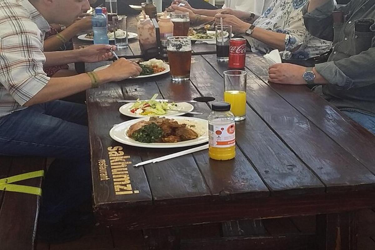 un gruppo di persone sedute a un tavolo di legno con piatti di cibo