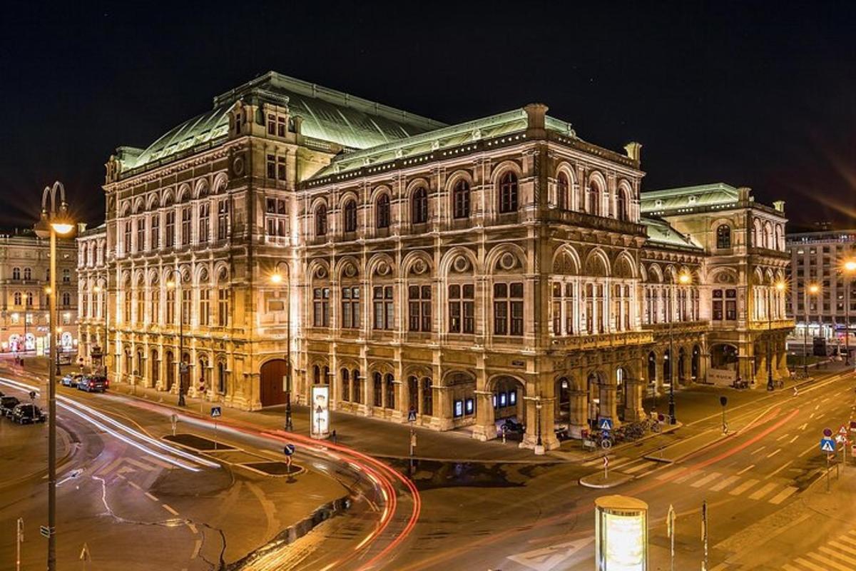 um grande edifício à noite com uma rua na frente