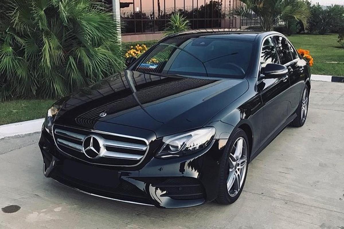 Černé auto Mercedes Benz zaparkované na příjezdové cestě