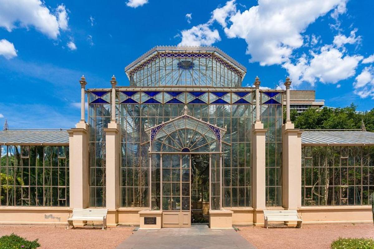 Un gran edificio de cristal con bancos delante.