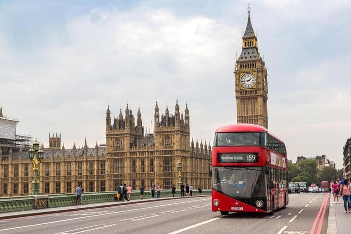 Červený dvoupatrový autobus projíždějící kolem hodinové věže Big Ben
