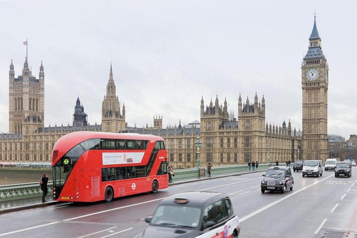 Červený dvoupatrový autobus projíždějící kolem hodinové věže Big Ben