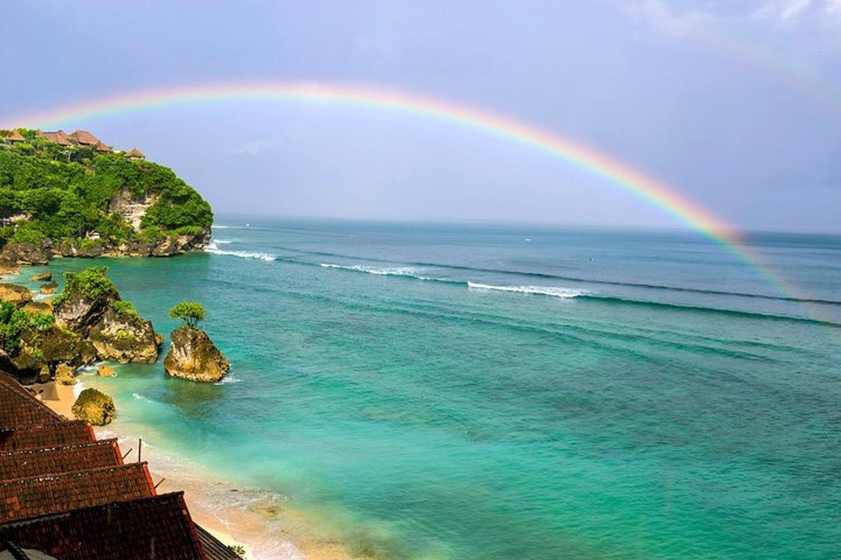 un arcobaleno sopra l'oceano con una spiaggia