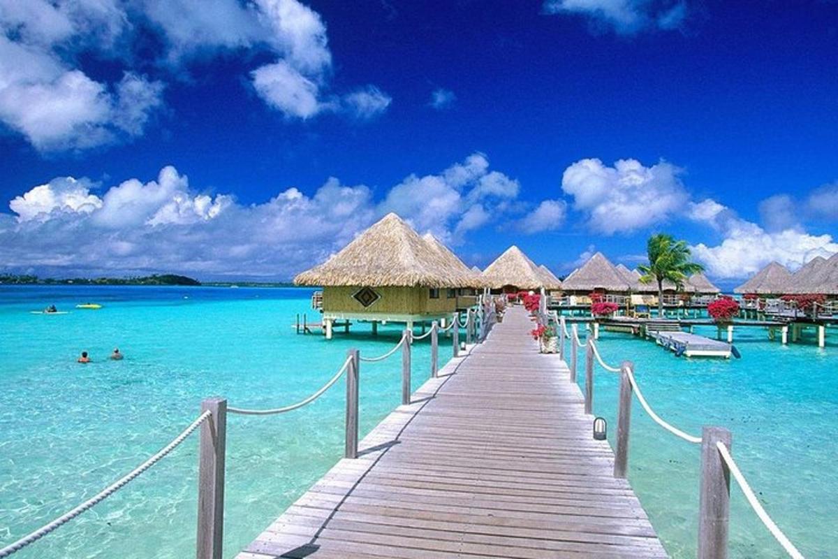 a dock in the water with a group of huts