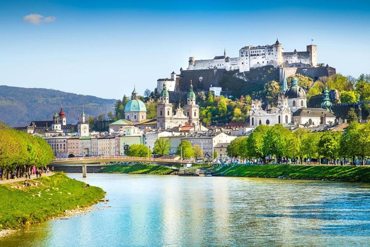 a city with a river and a castle on a hill