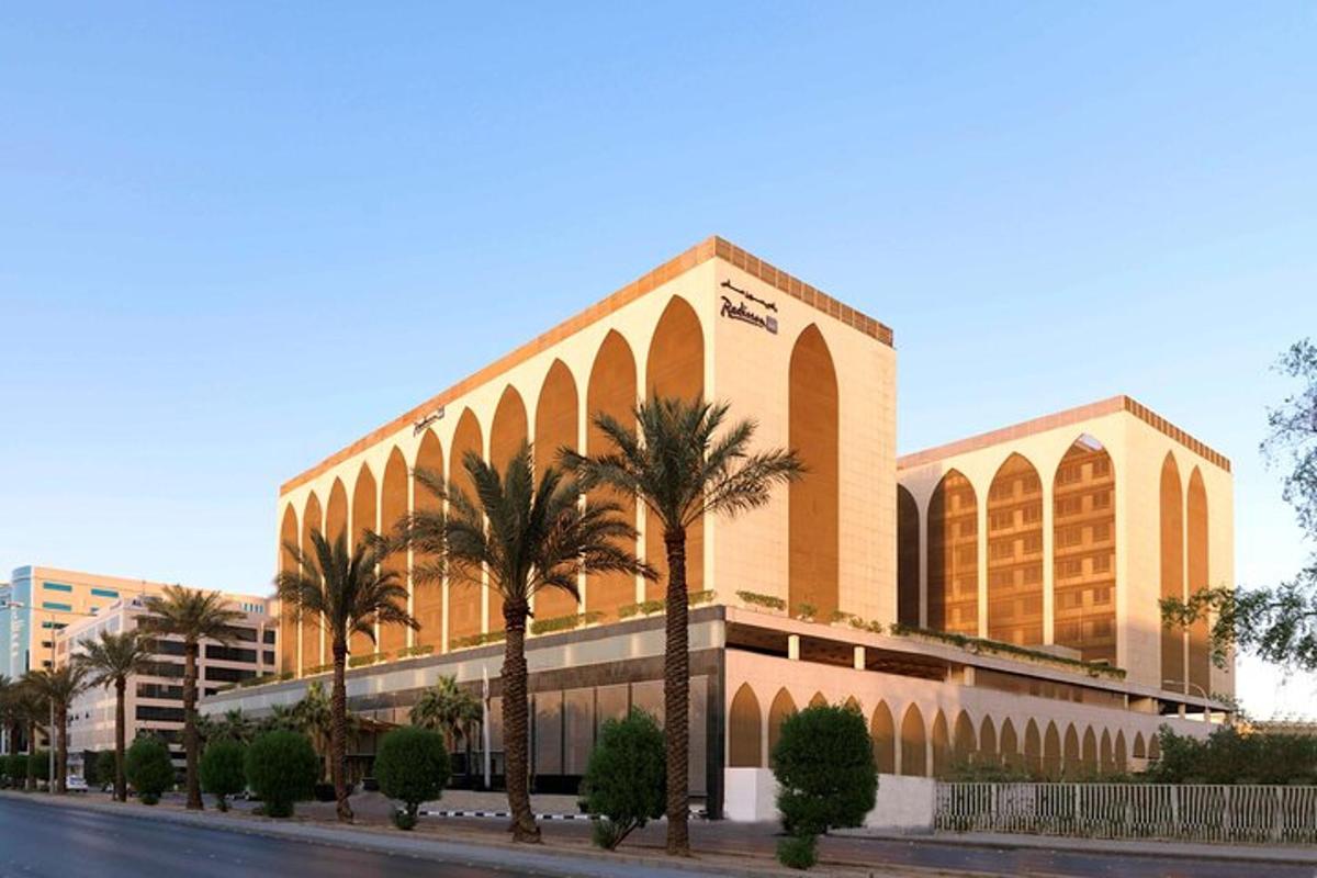 a building with palm trees in front of a street