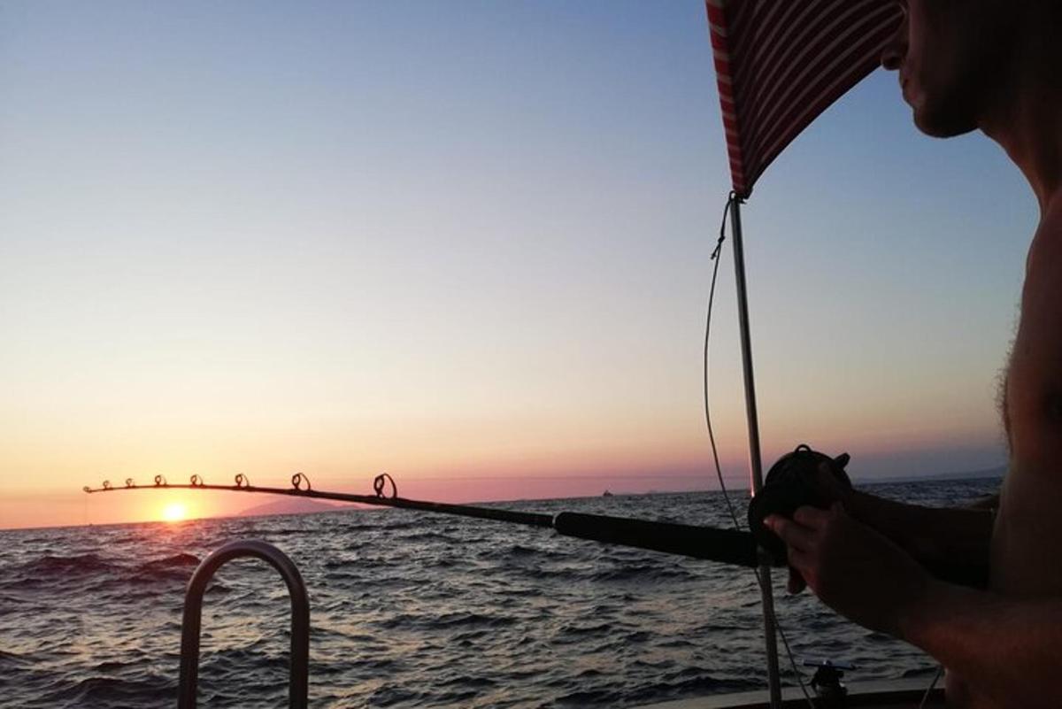 žena držící rybářský prut na lodi v oceánu