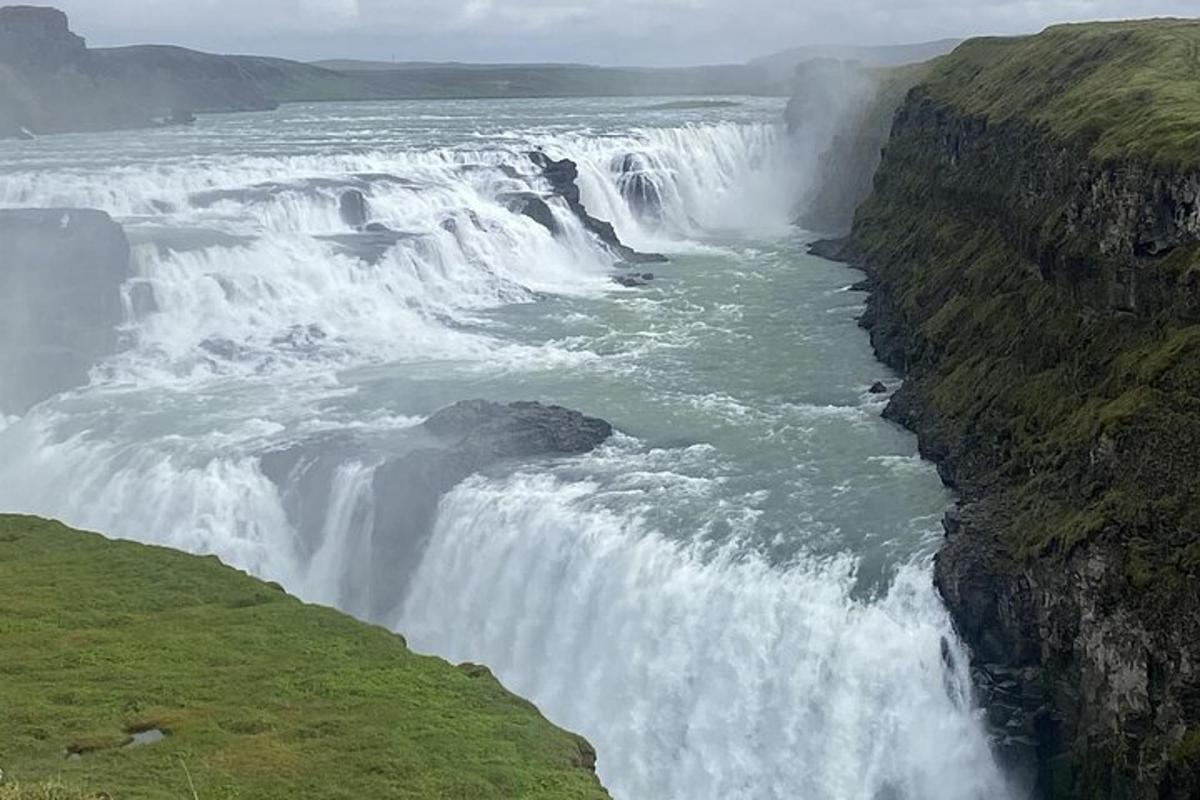 una cascata sul fianco di una scogliera accanto a un fiume