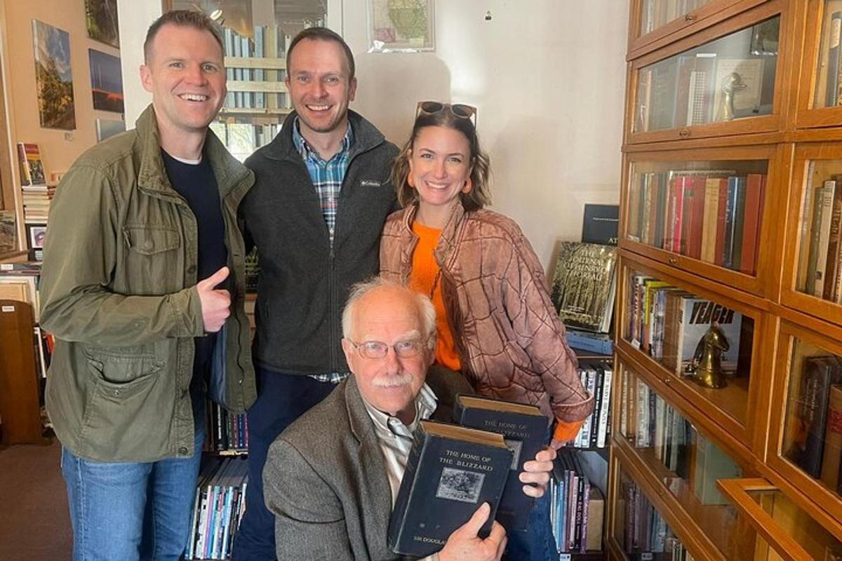un grup de persones al voltant d'un home en una biblioteca