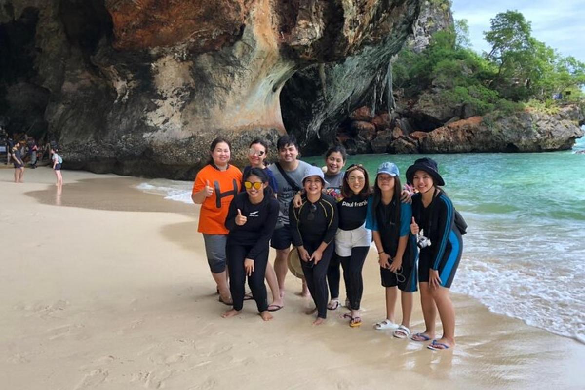 eine Gruppe von Menschen posiert für ein Foto am Strand